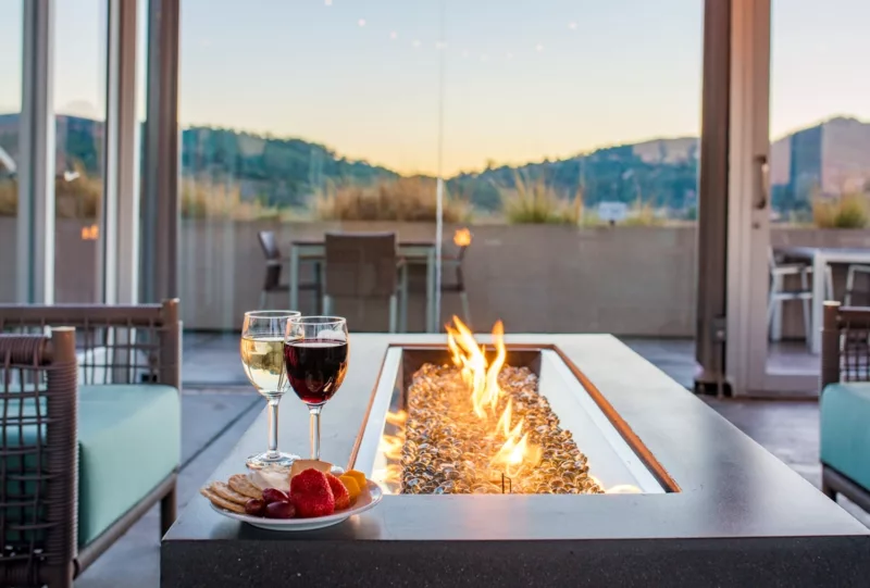 fire feature with table and two wine glasses and cheese plate with hill views in the background
